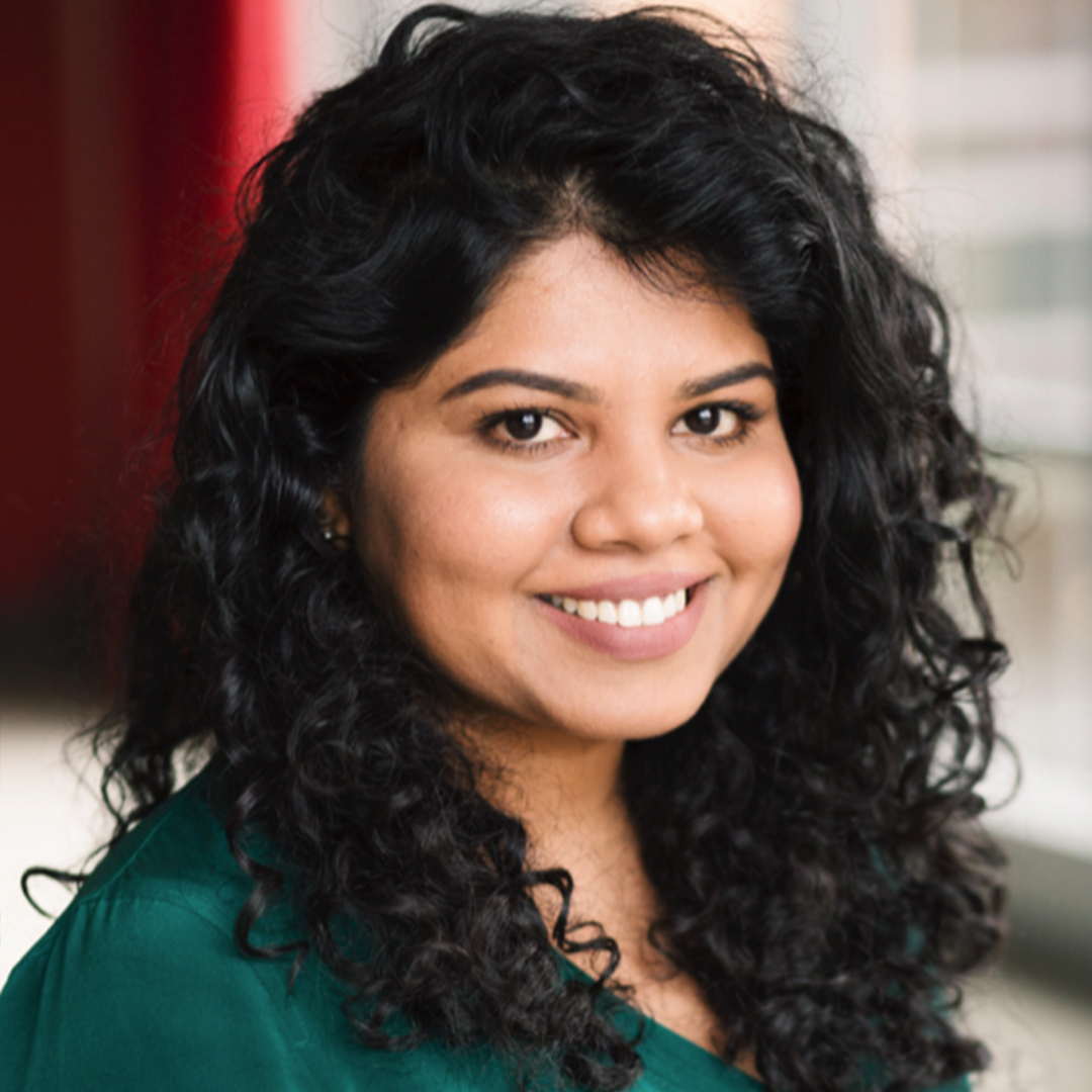 Headshot of Jennifer Collins smiling, wearing a green top with curly hair