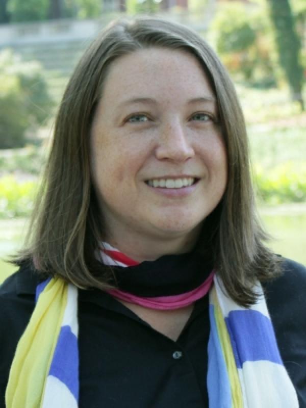 Headshot of Brittany Shoots-Reinhard wearing a black blouse and colorful scarf around her neck