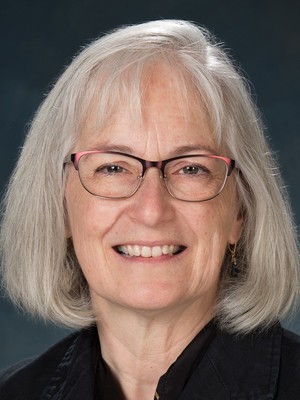 Headshot of Carole Breitenberger wearing red glasses and smiling