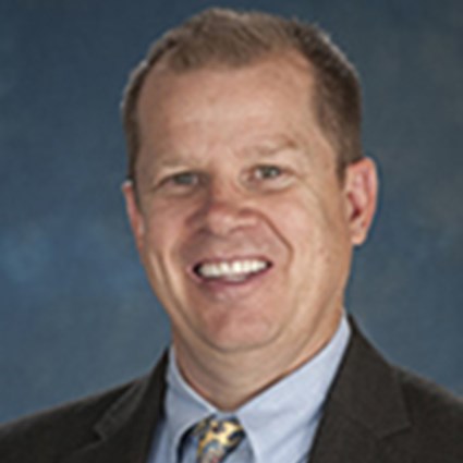 Headshot of Christopher Wolters smiling and wearing a suit