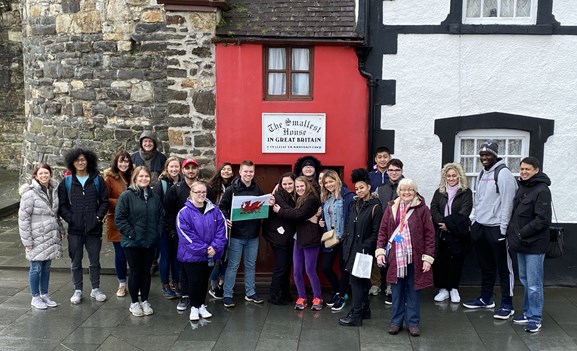 Study abroad trip to Wales in front of the world's smallest house.