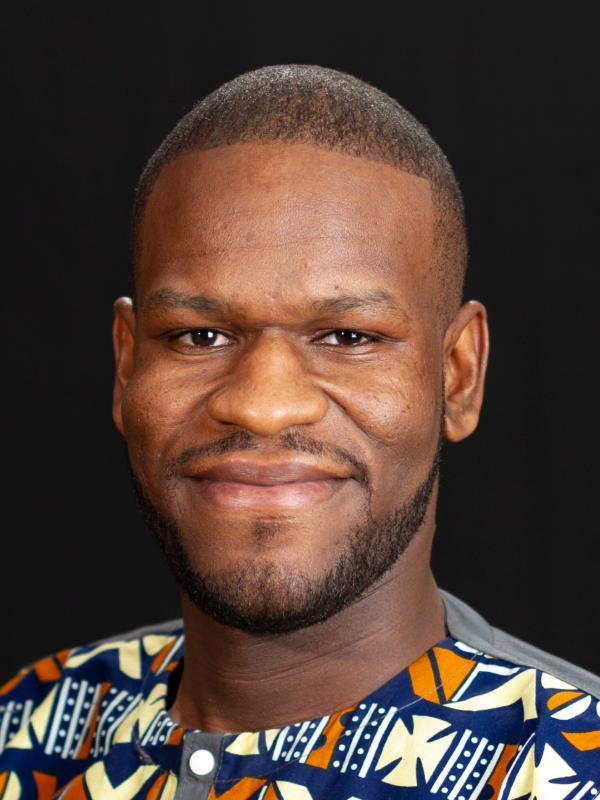 Headshot of Shadrick Addy wearing a colorful shirt.