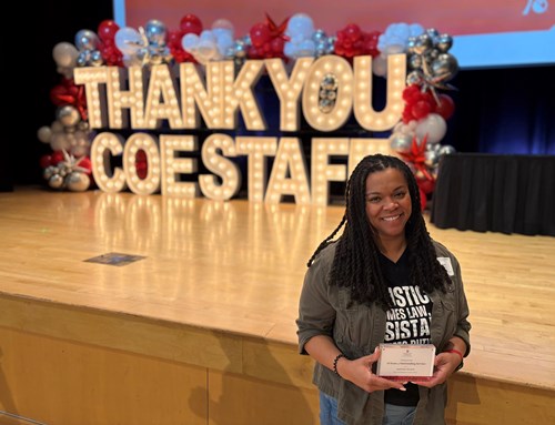 Gisell holding an award in front of a stage