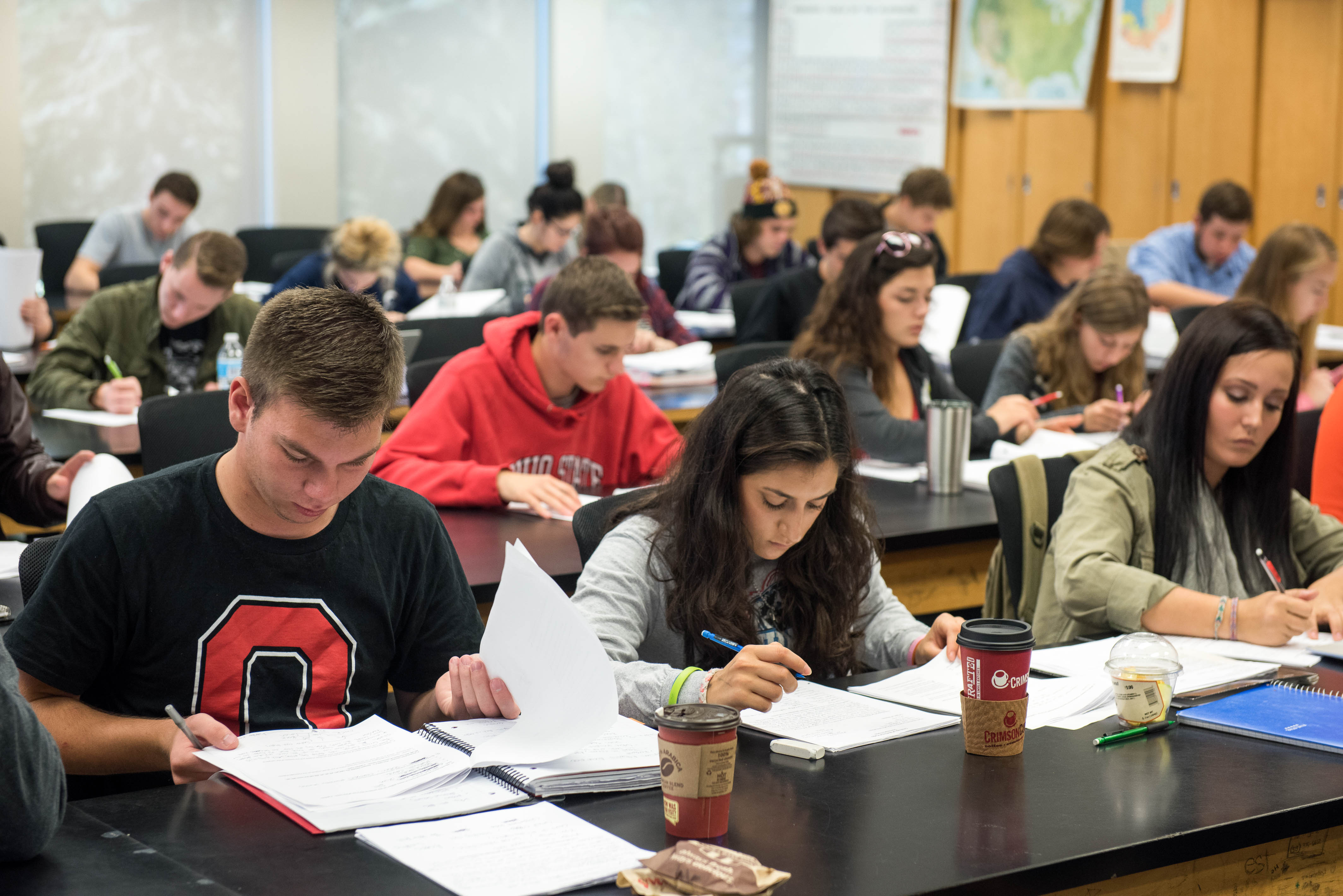 A large group of students reading and studying within a classroom setting