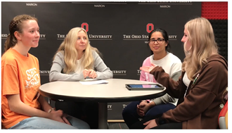 Donna with a panel of three students.