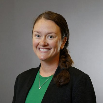 Headshot of Emily Dringenberg wearing a green shirt and black dress jacket.