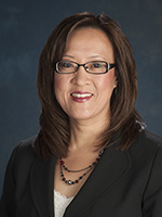 Headshot of Shirley Yu smiling, with black glasses, and a black suit