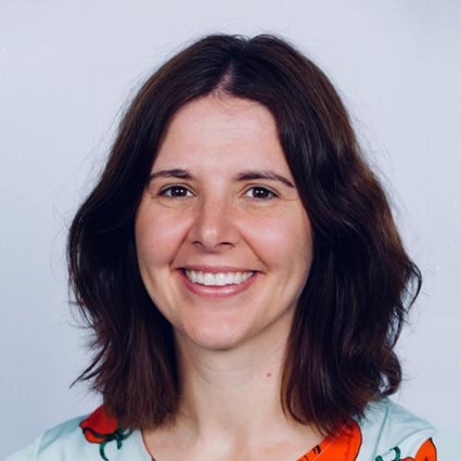 Headshot of Nicole Kwiek wearing a light blue and orange blouse.