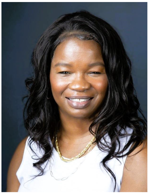 Woman in sleek sleeveless white top smiling at camera.
