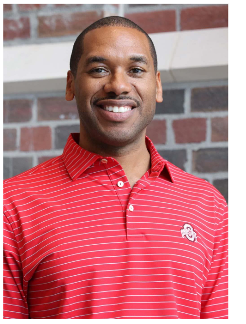 Man in red striped Ohio State polo smiling at camera.