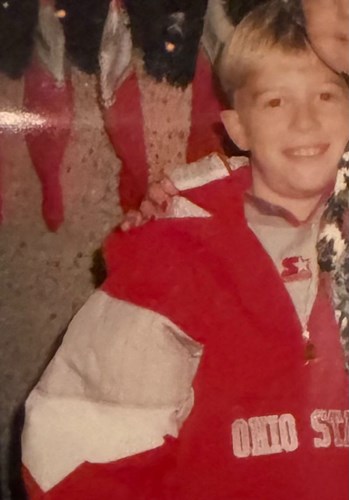 Young person wearing a Starter brand Ohio State jacket