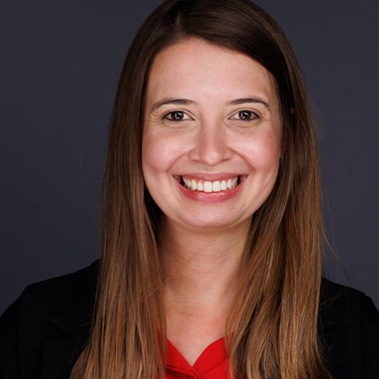 Headshot of Fernanda Krupek wearing a red shirt and black jacket.